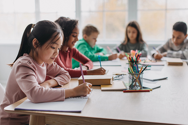 A young girl writes on a piece of paper