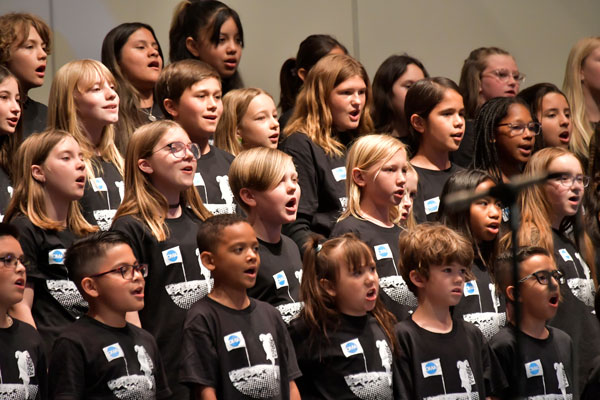 Students sing in a choir during the OMA showcase.