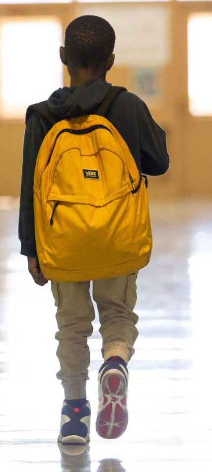 Boy walking away with backpack