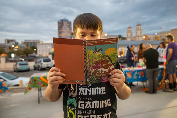 A little boy reads the school garden almanac