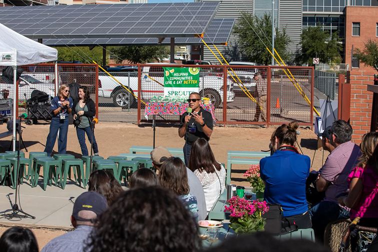 A man speaks into a microphone in the new garden space