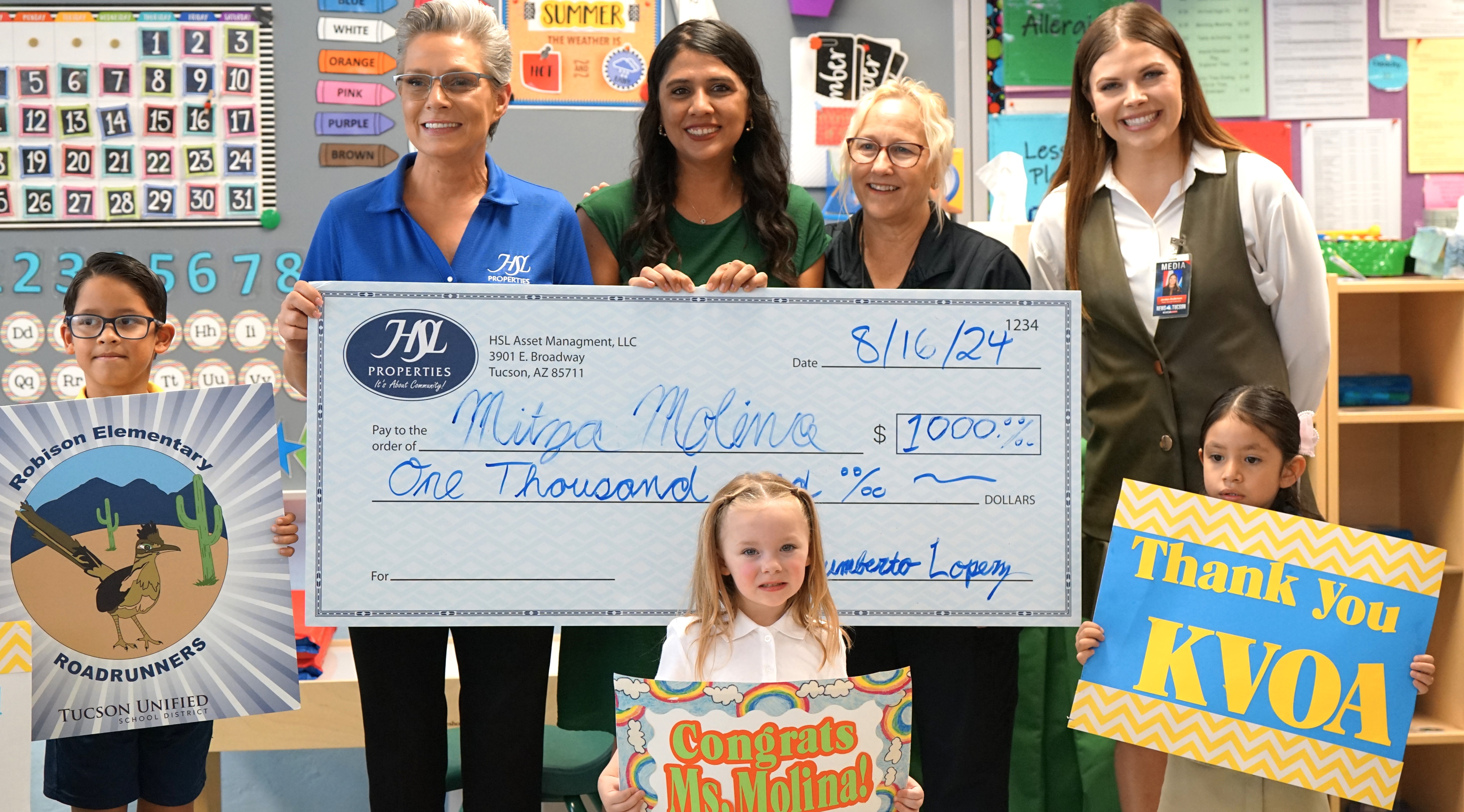 Robison preschool teacher Mitza Molina poses with students and her principal with her check from HSL Properties