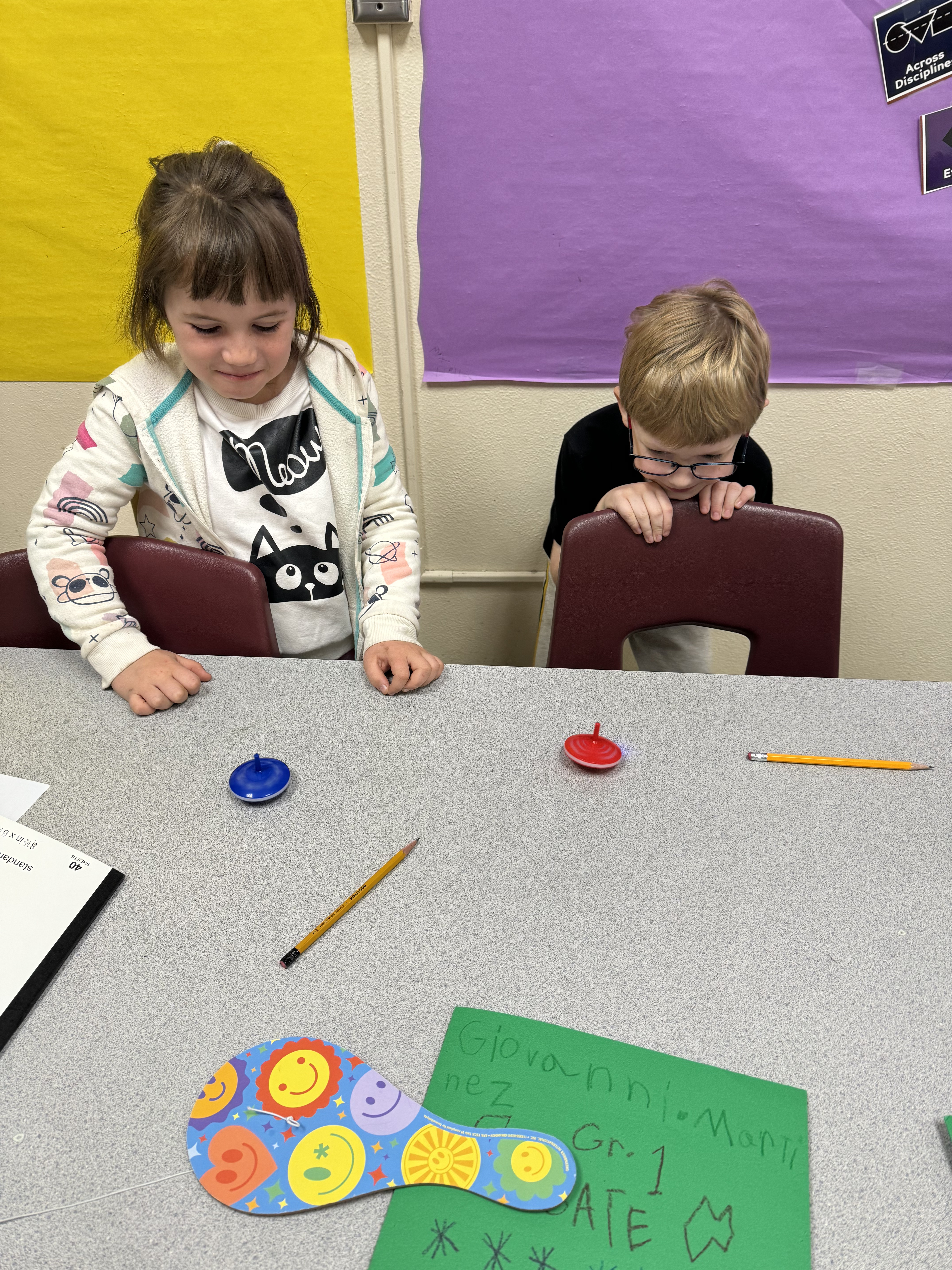 Students playing with toy tops.