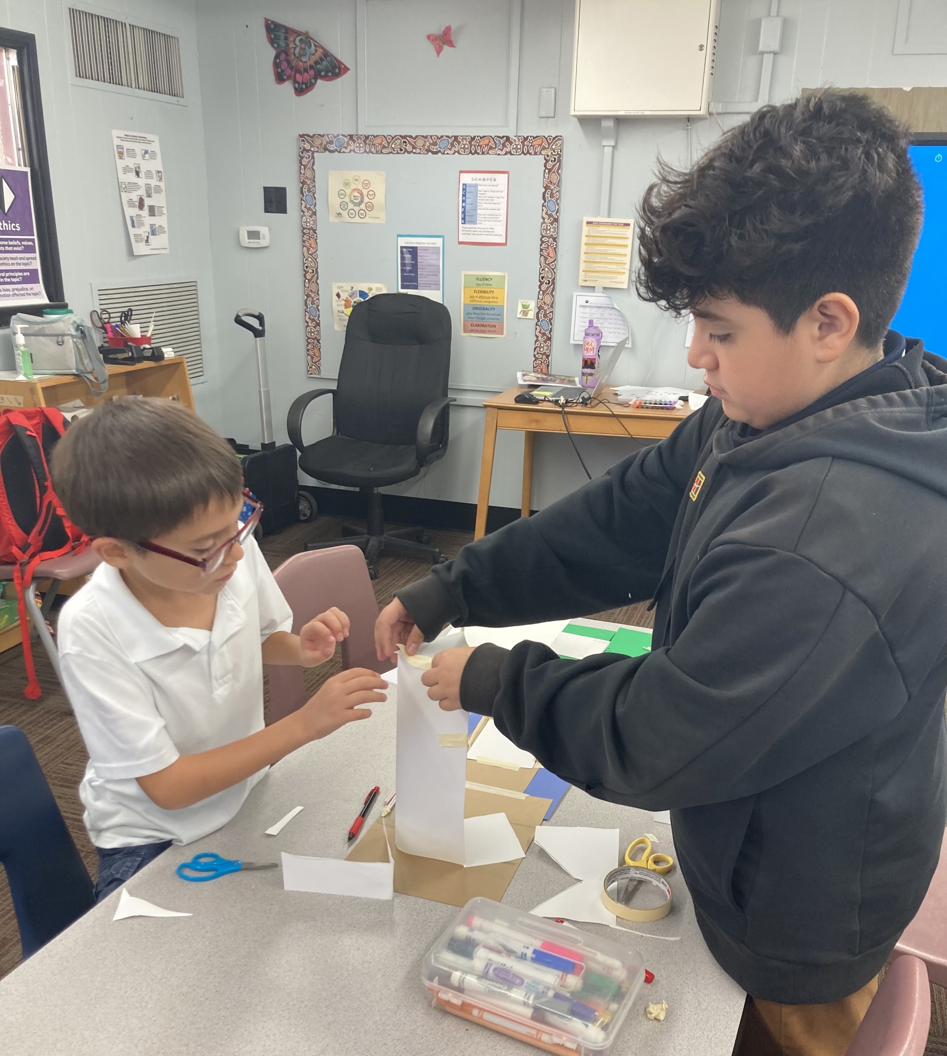 Picture features two of Mrs. Gallus's students making a shelter for the Survivor unit. 