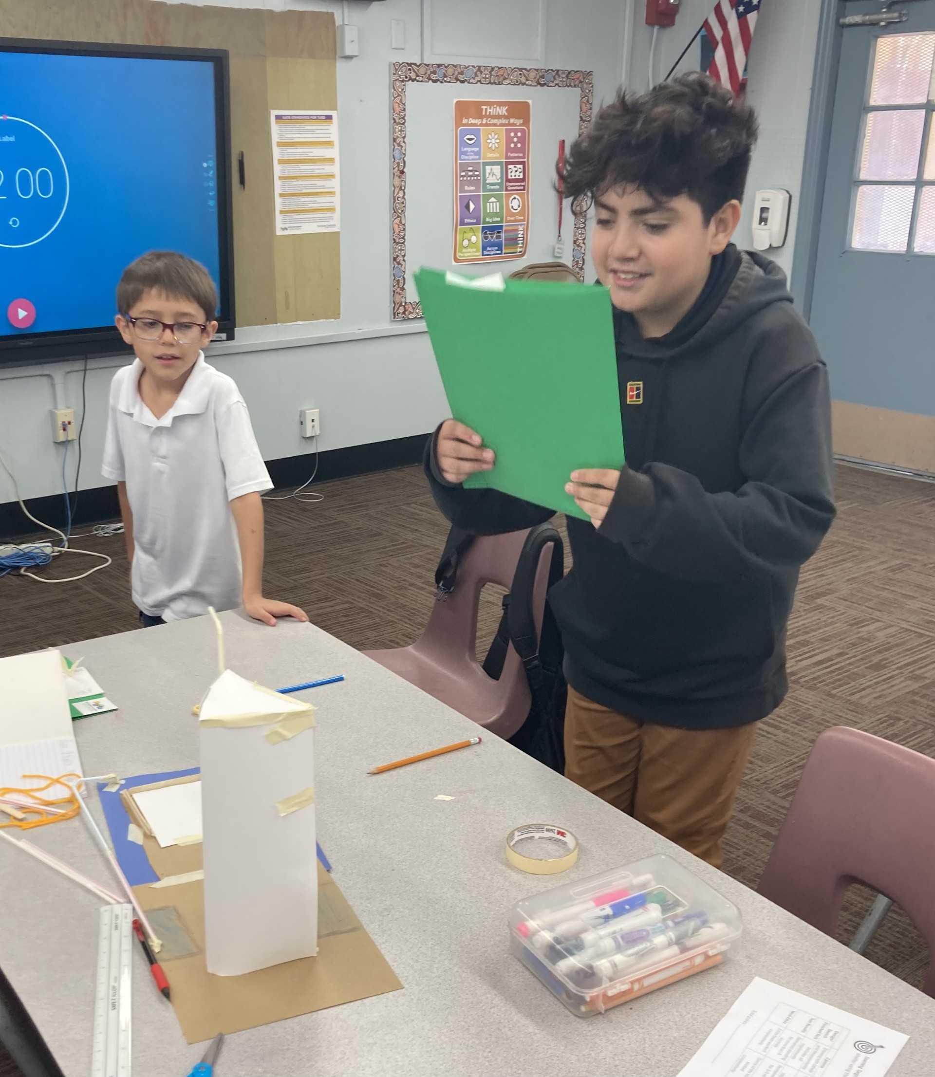 Picture features two of Mrs. Gallus's students making a shelter for the Survivor unit. 