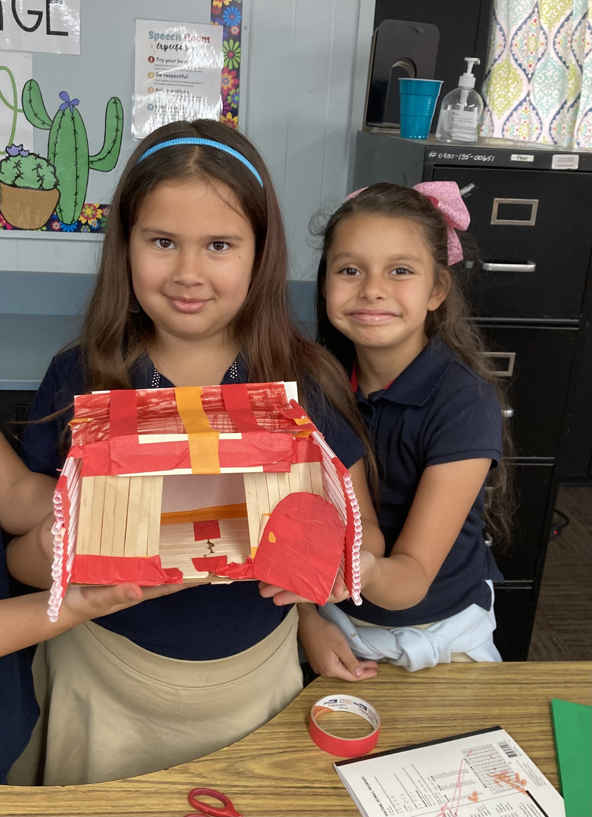 Picture features two of Mrs. Gallus's students making a shelter for the Survivor unit. 