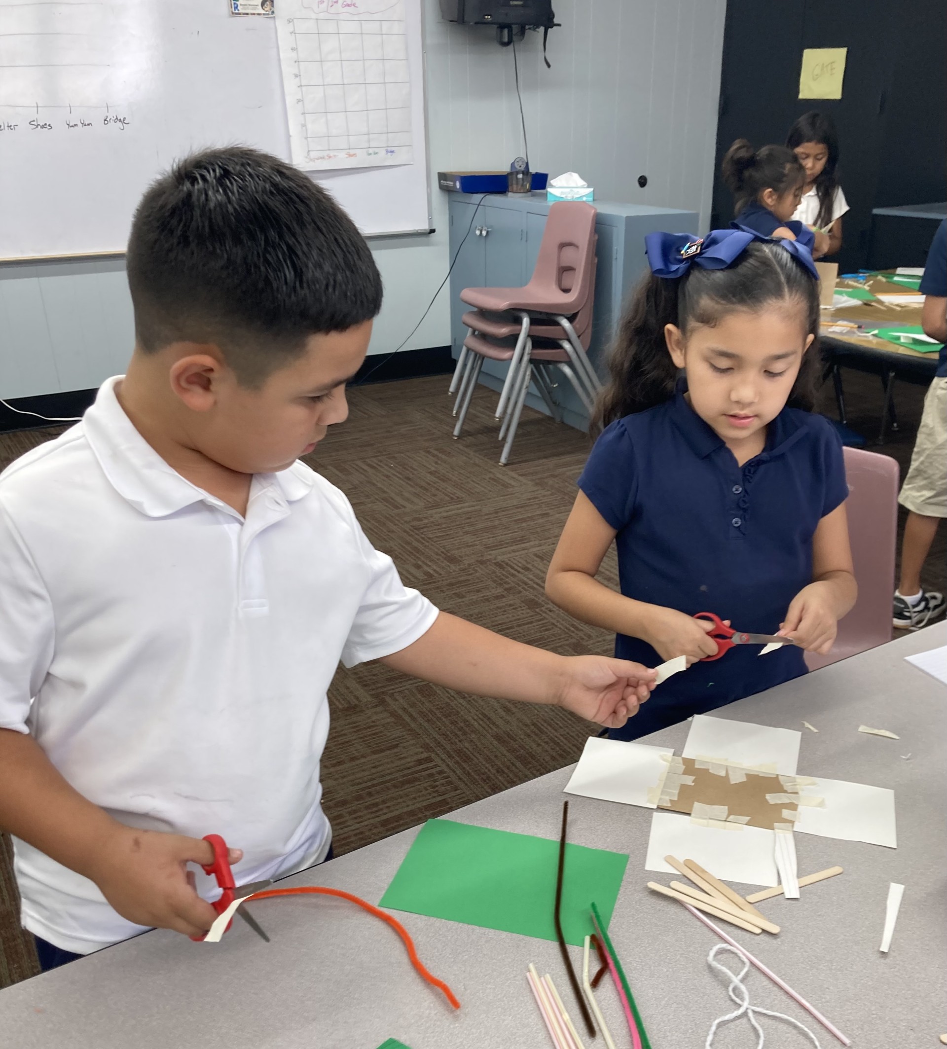 Picture features two of Mrs. Gallus's students making a shelter for the Survivor unit. 