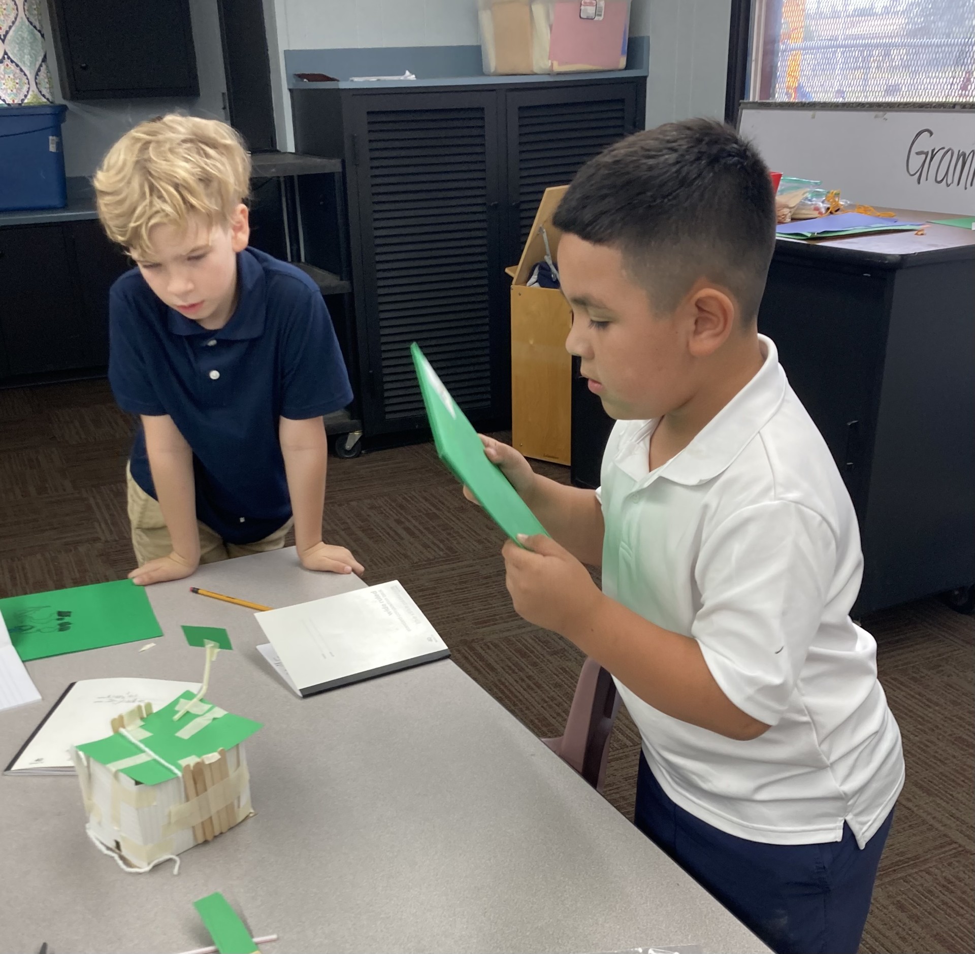 Picture features two of Mrs. Gallus's students making a shelter for the Survivor unit. 