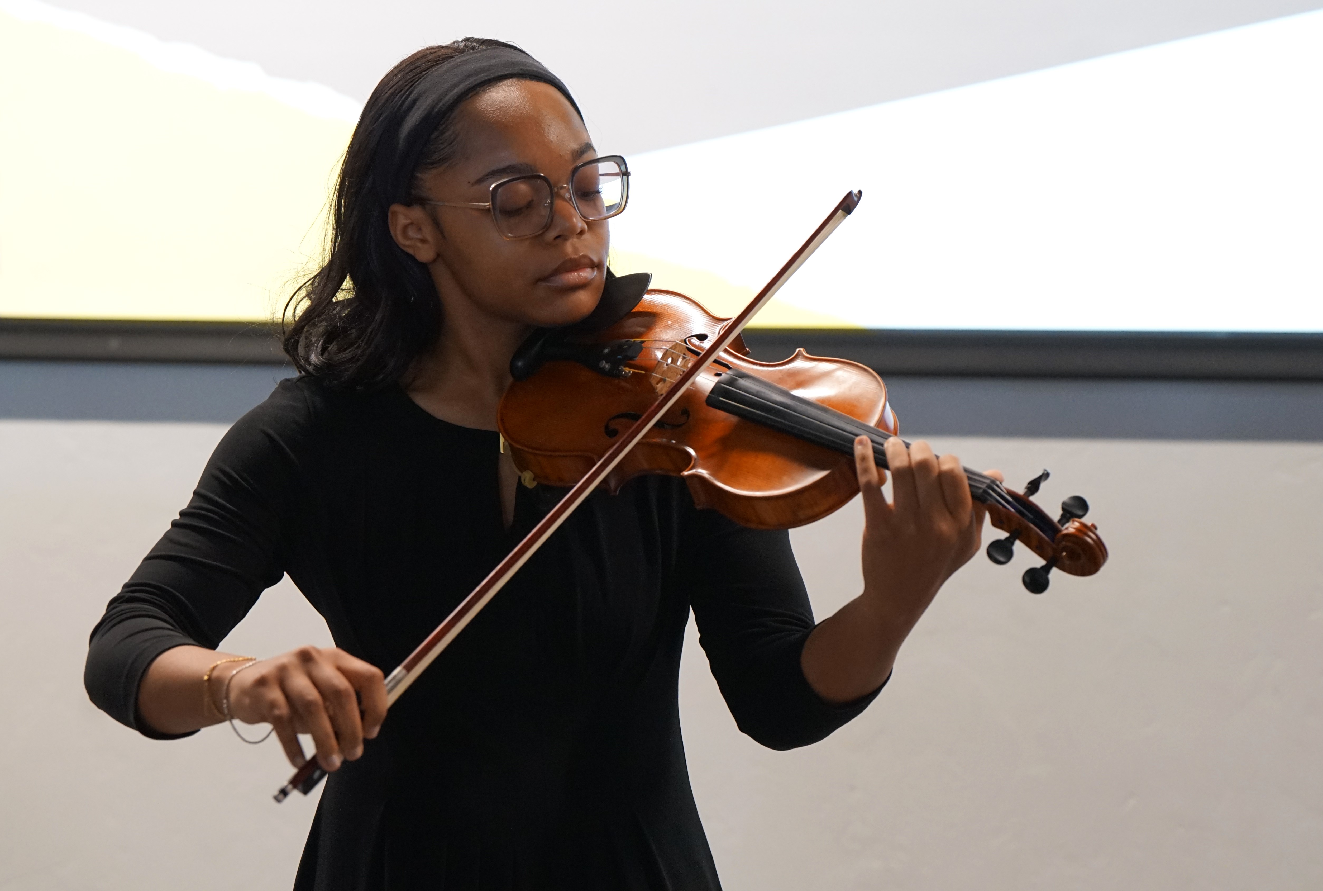 A girl in glasses plays violin