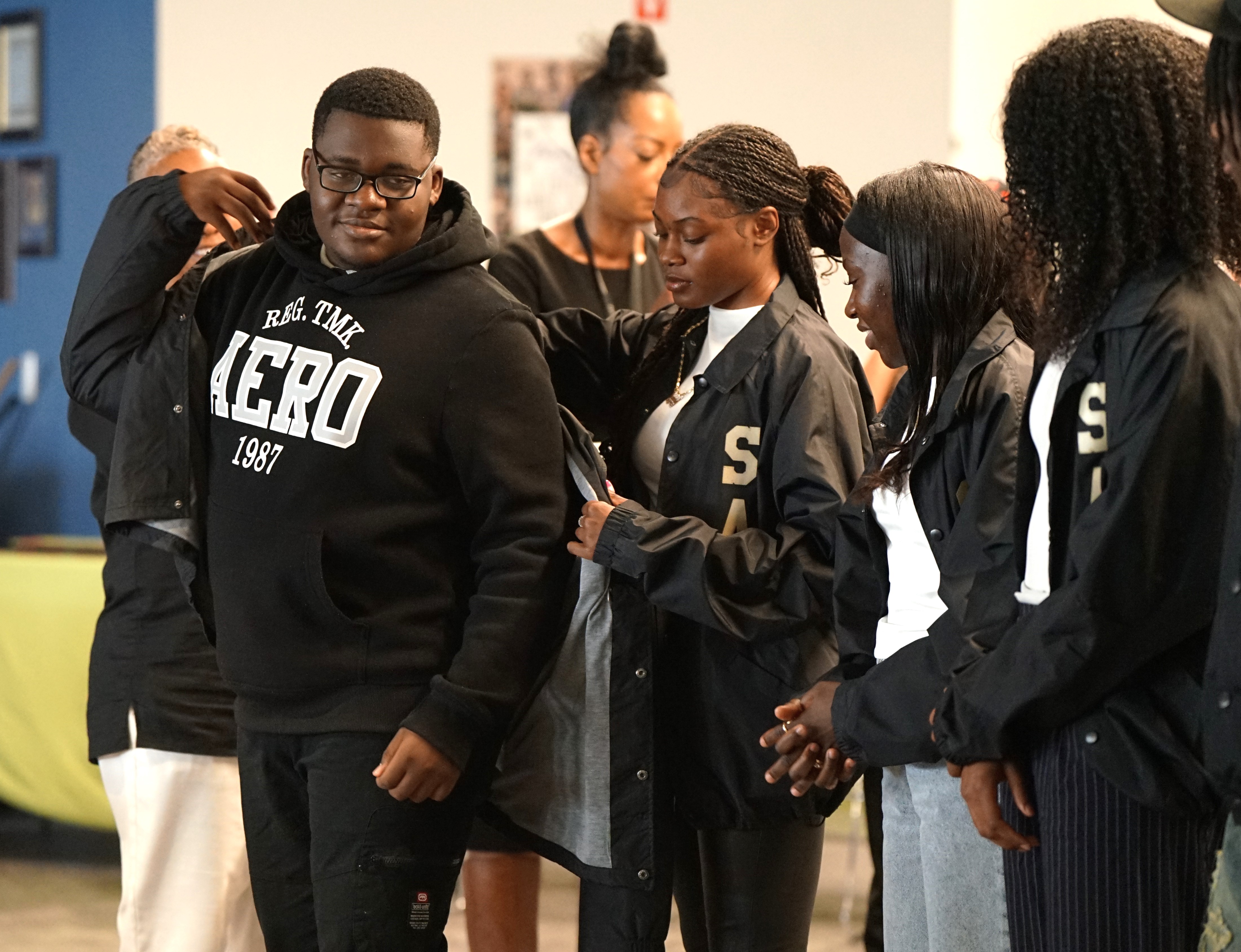 A boy in glasses gets his jacket during the coating ceremony