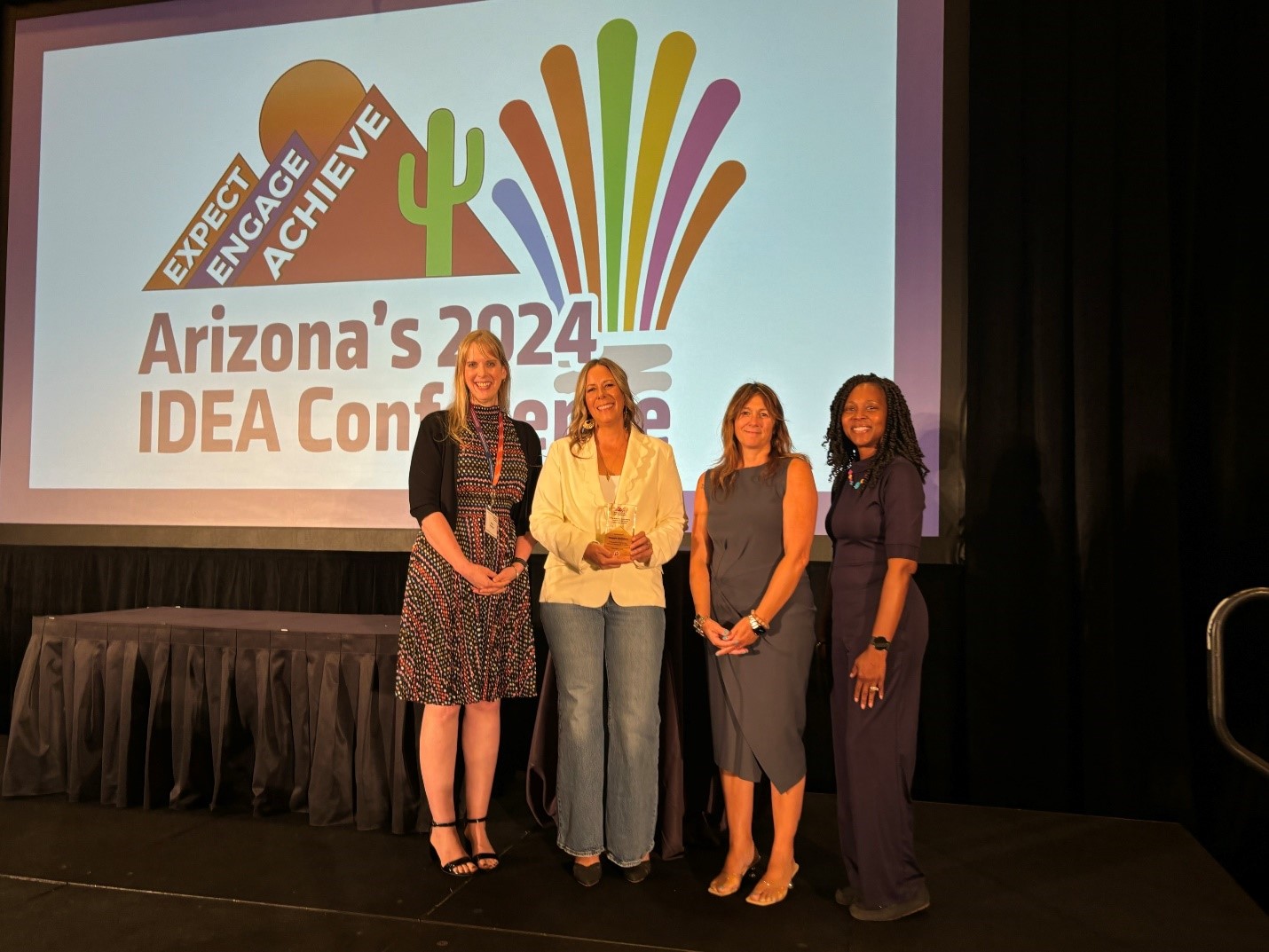 Maggie Gedebou (second individual from left to right) receiving the Secondary Transition Services Award at the 2024 IDEA Conference. To her right is Alissa Trollinger, the Deputy Associate Superintendent of Exceptional Student Services (ESS) at the Arizona Department of Education (ADE). To her left is Angela Odom, the Senior Director of Program Support and Monitoring at ADE ESS, and Dr. Sabrina Salmon, TUSD’s Senior Director of the Exceptional Education Department.