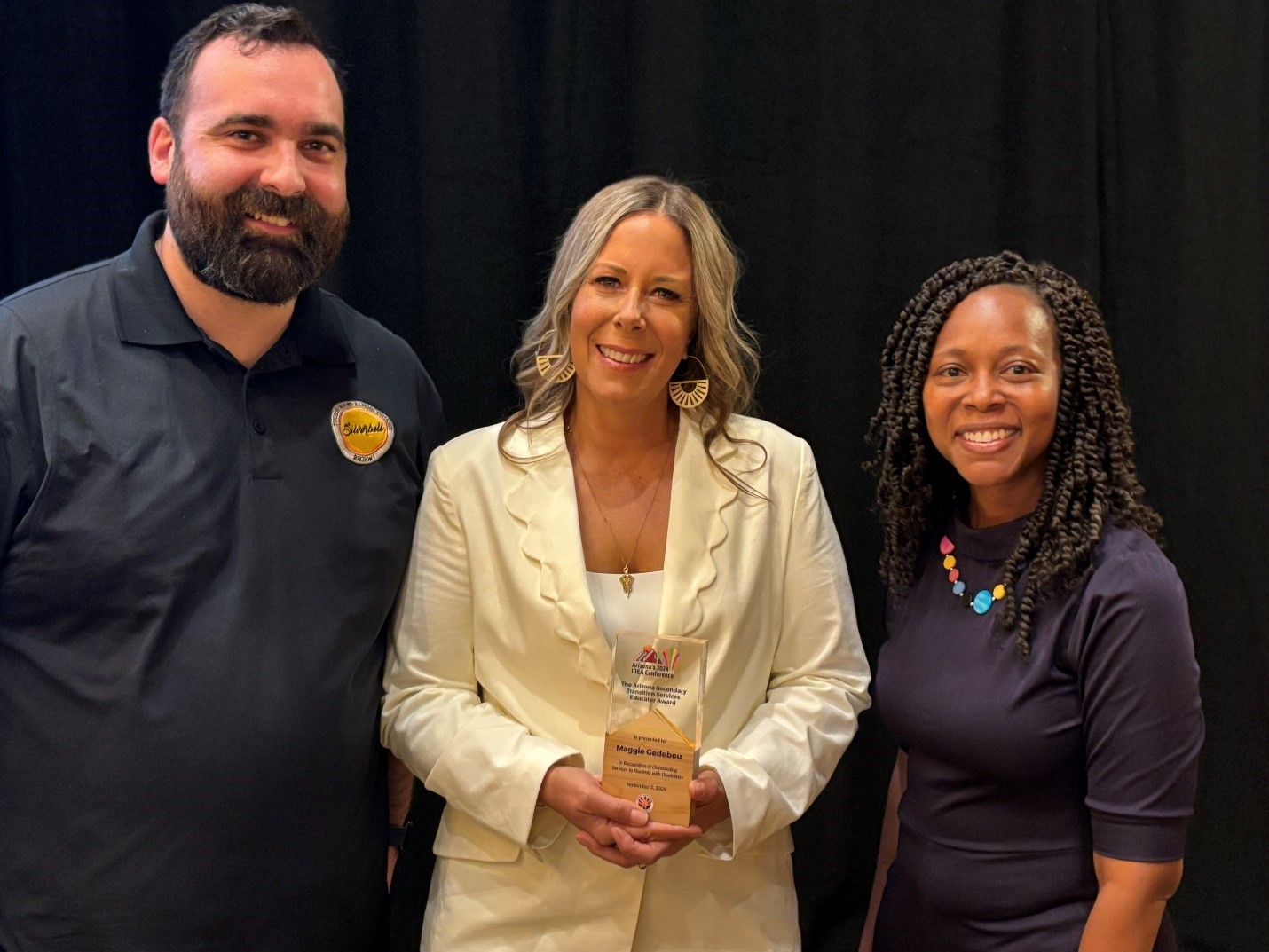 Maggie Gedebou holding her award and standing between Vito Peppetoni, the Region 1 Assistant Director, and Dr. Sabrina Salmon, the Senior Director of the Exceptional Education Department. 