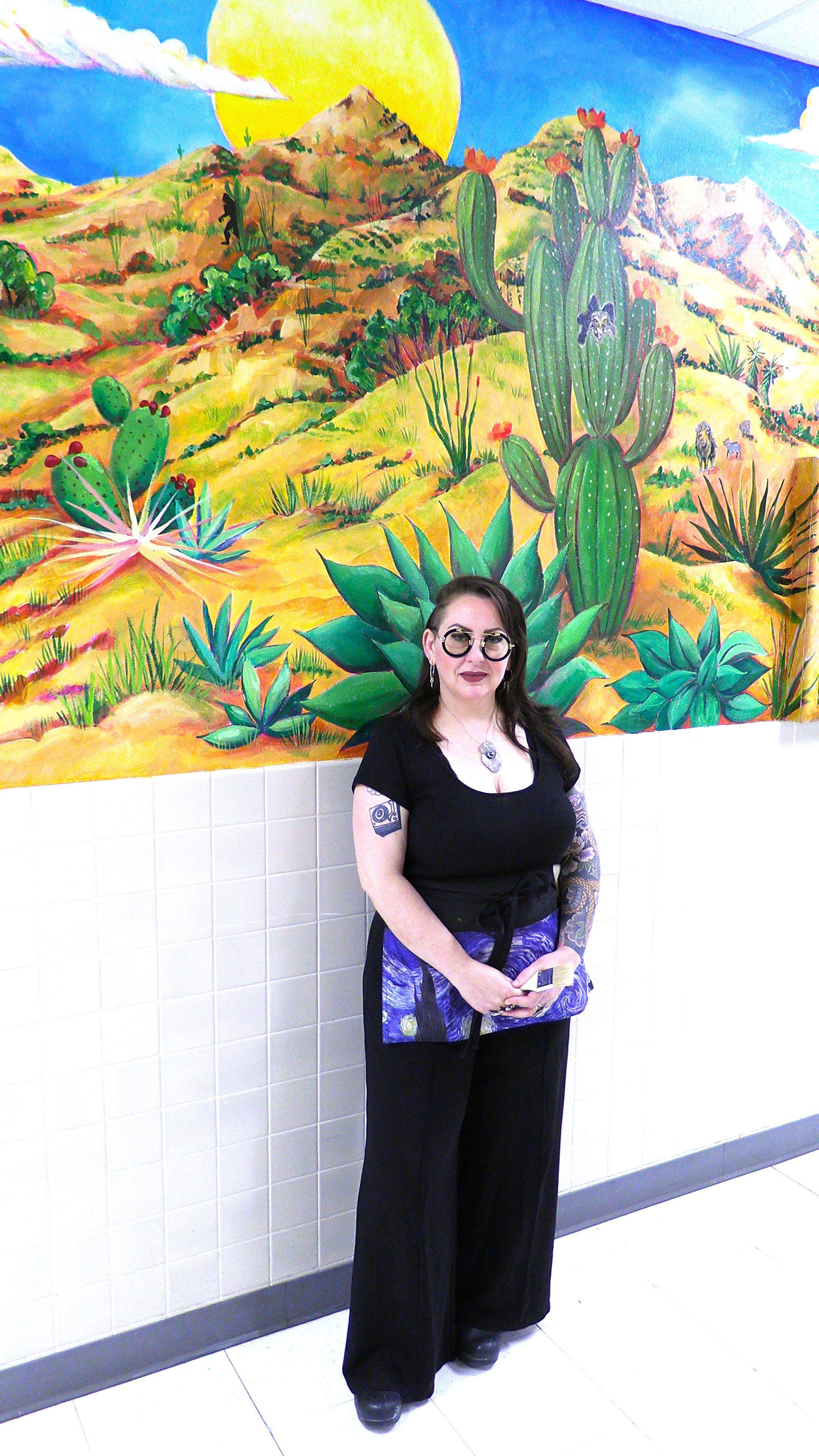 Leanne Miller stands in front of the mural she creared