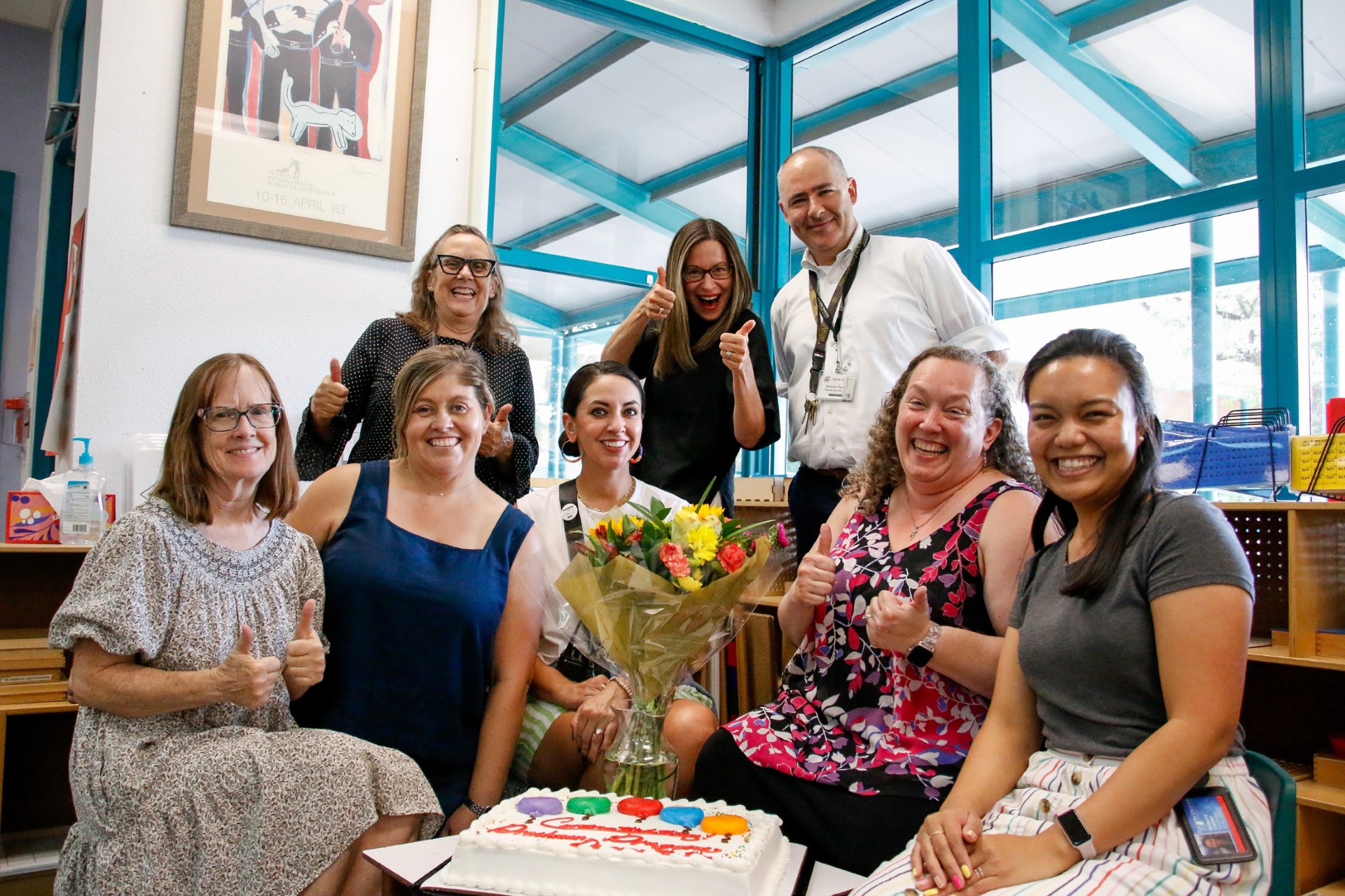 Drachman's magnet team smiles for a photo with their celebratory flowers and cake