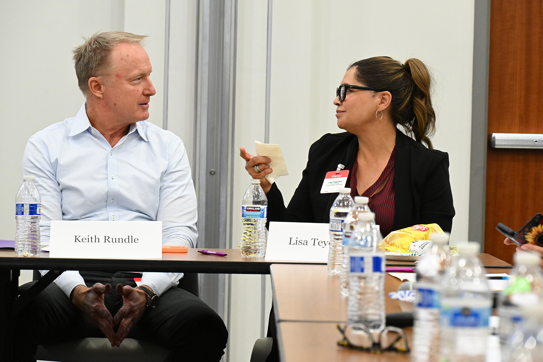 A man and a woman talk at their table during the summit