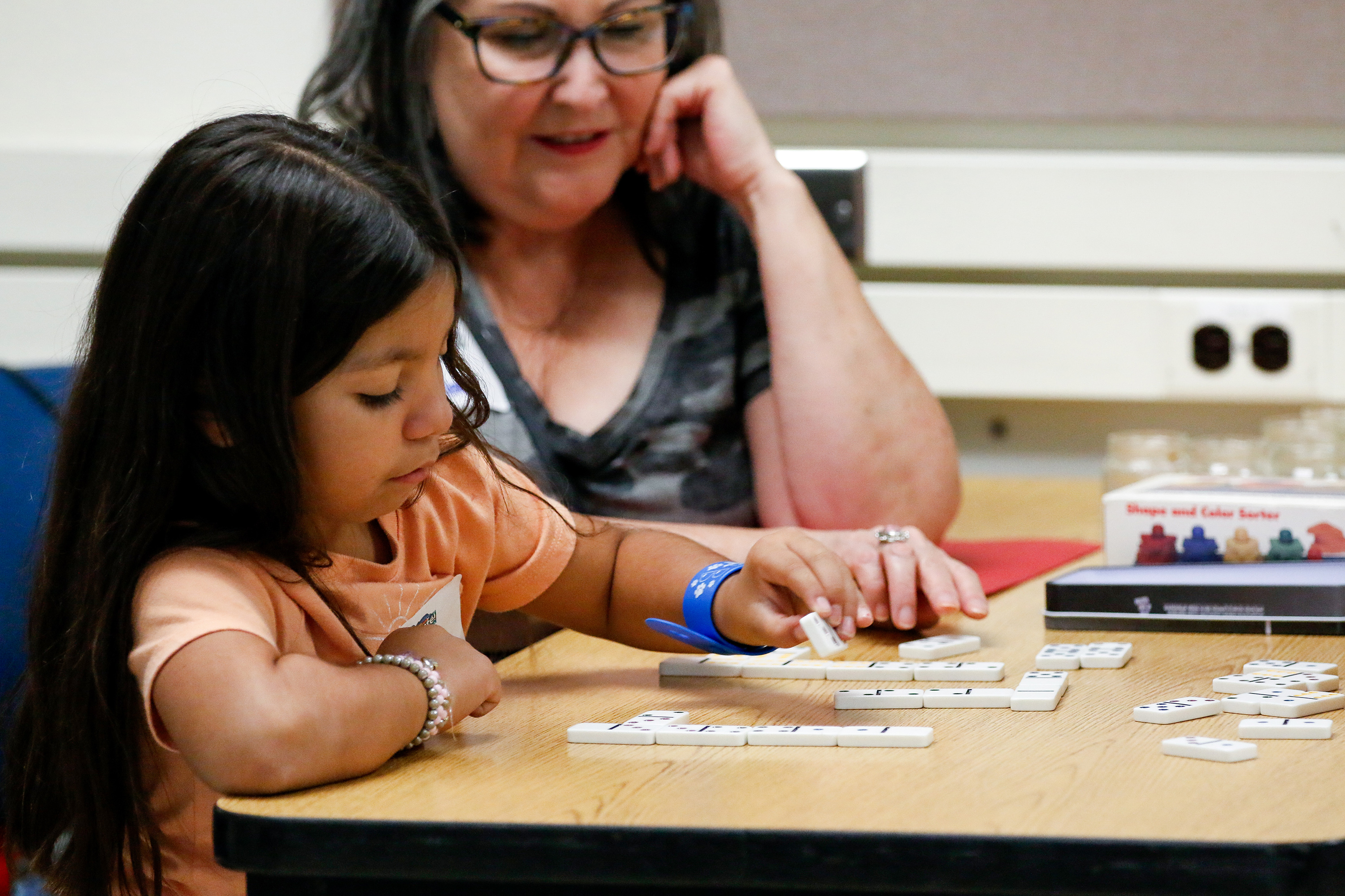 A little girl plays with letter tiles