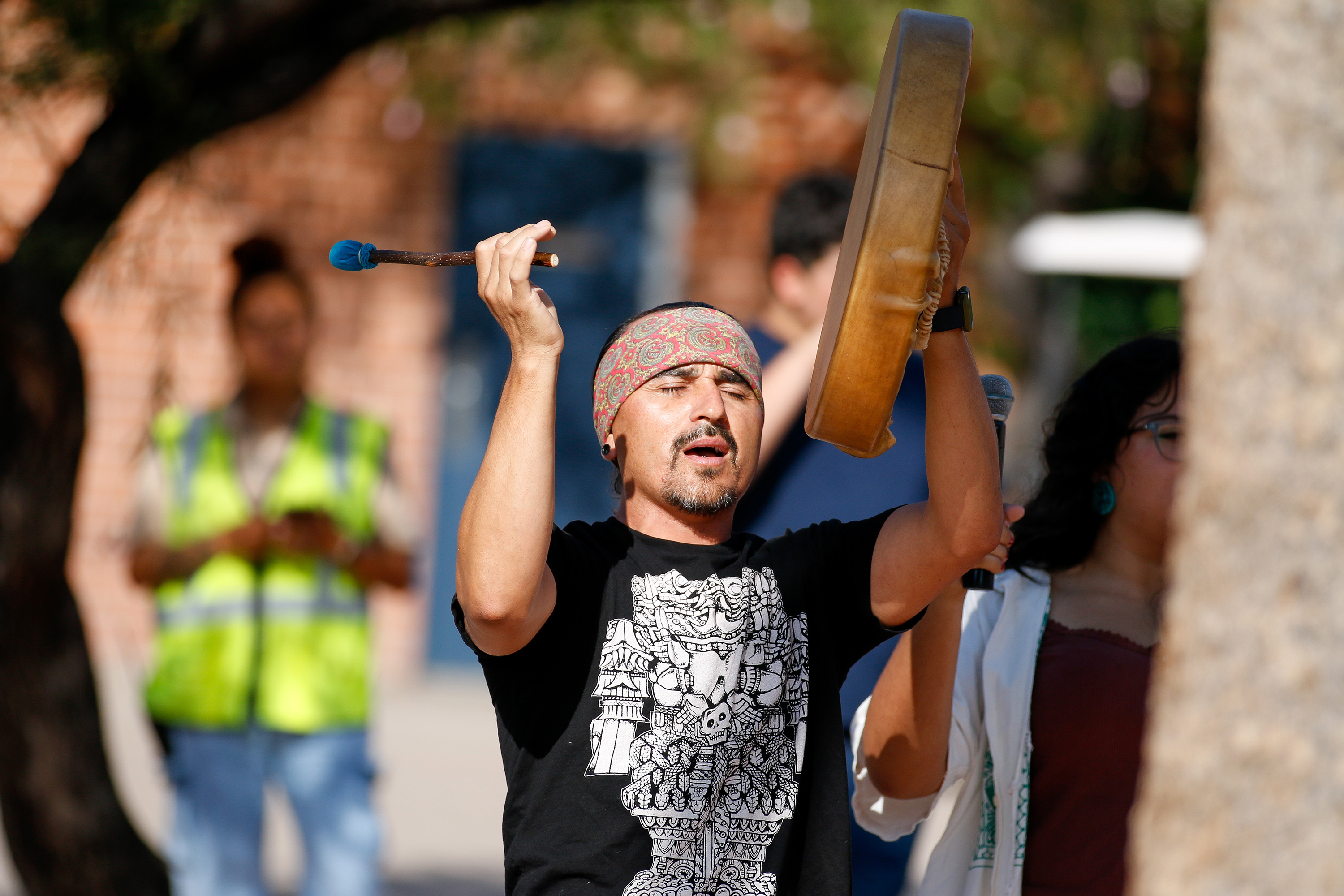 A drummer holds his drum up during his performance