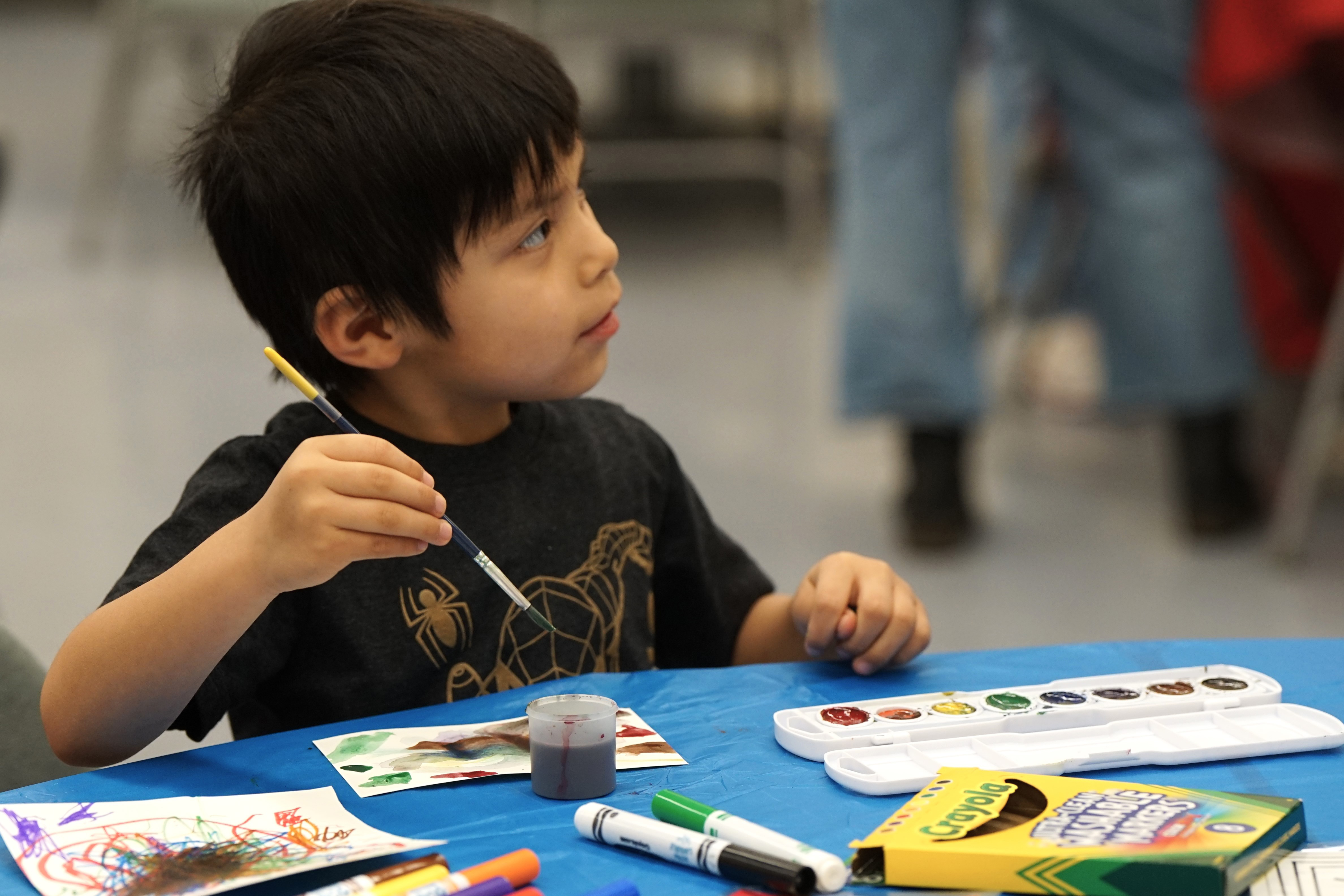 A little boy paints with watercolors