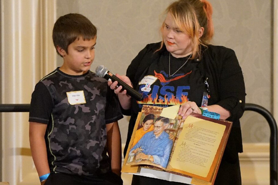 A student reads a passage from the Raulito book to conference participants